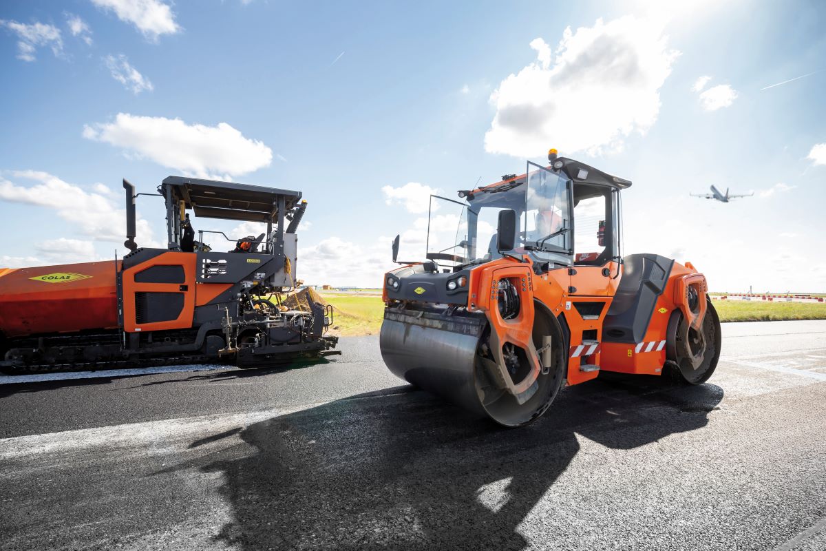 Travaux de voirie avec un compacteur et un finnisseur sur une piste aéroportuaire