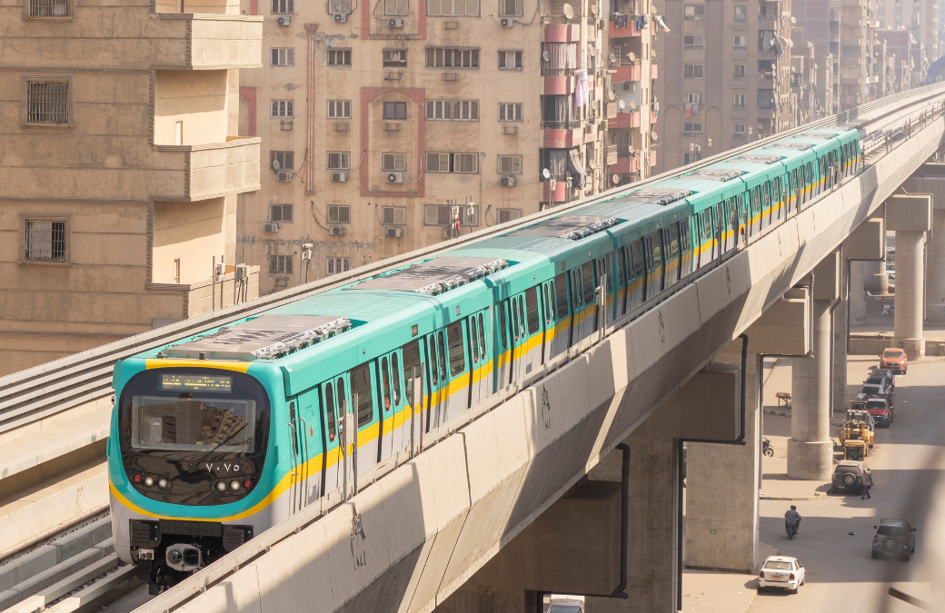 Metro circulating on an overhead line between residential buildings in a dense urban area