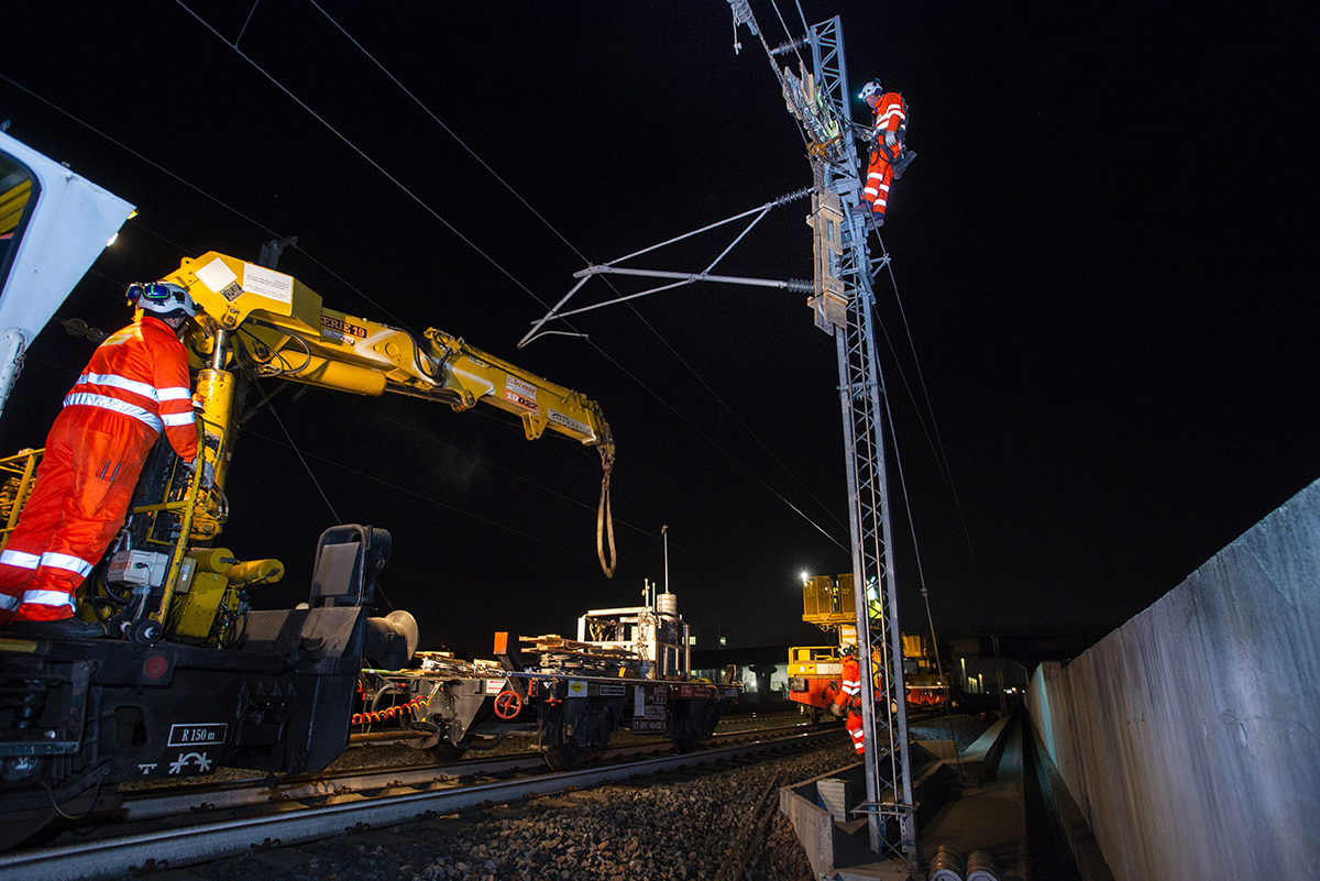 Scène nocturne où des collaborateurs sont impliqués dans la maintenance ferroviaire