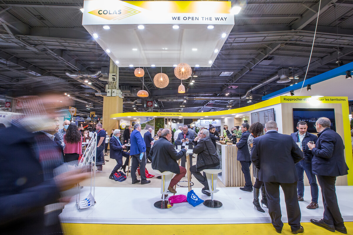 Animated scene captured during a trade show on a yellow stand in the colors of Colas