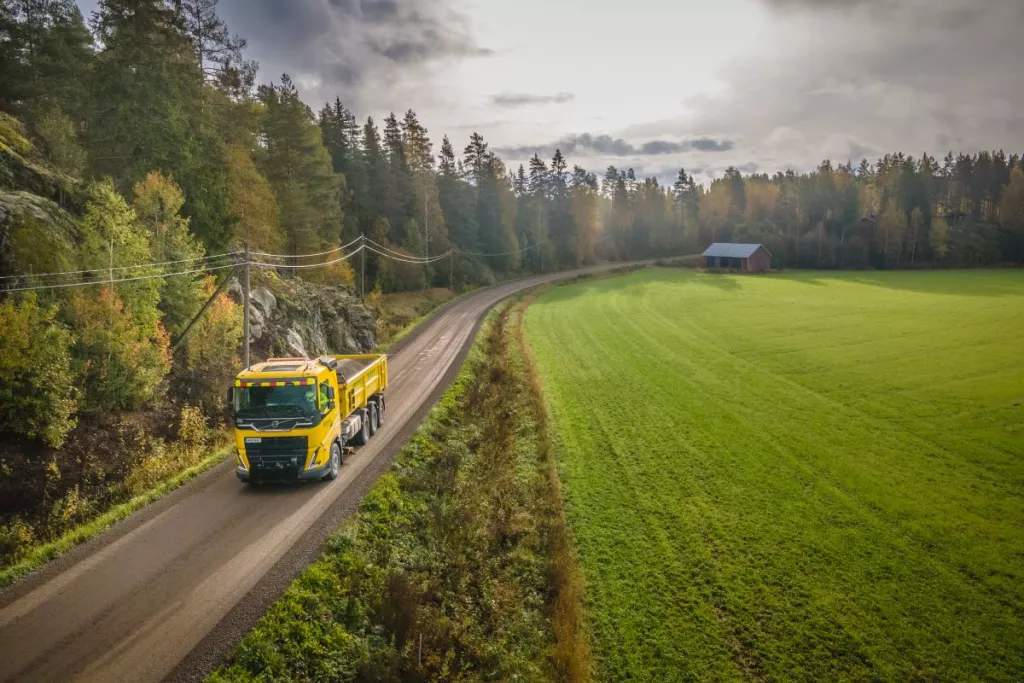 Truck on a country road surrounded by forests and fields