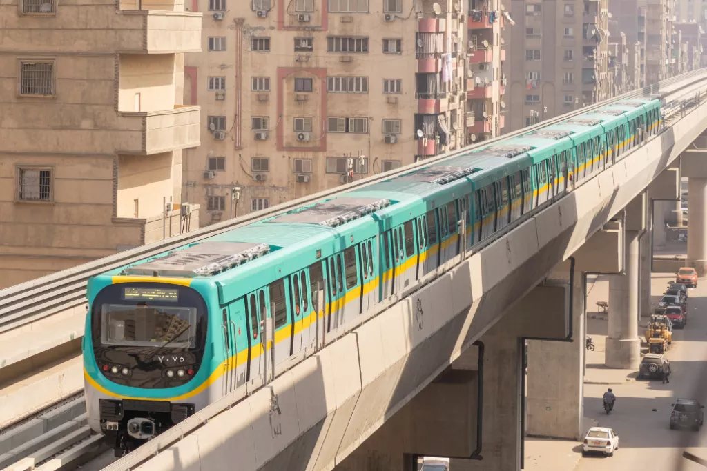 Metro circulant sur une ligne aérienne entre des immeubles d'habitation dans une zone urbaine dense