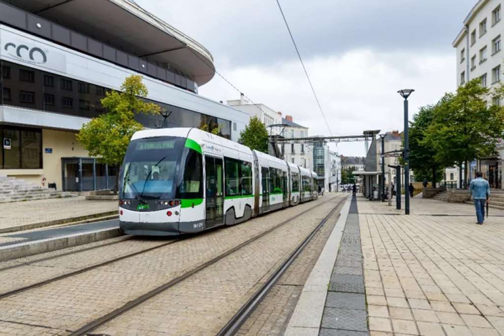 Tramway blanc et vert qui stationne à une station