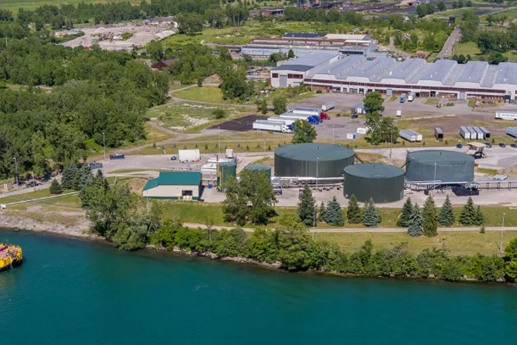 Industrial waterfront facility with storage tanks and docked ship.
