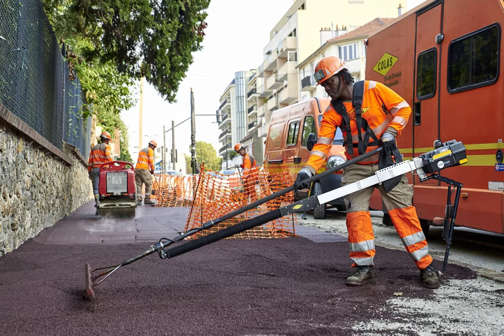 Collaborateurs qui reconstruisent la surface d'un trottoir urbain