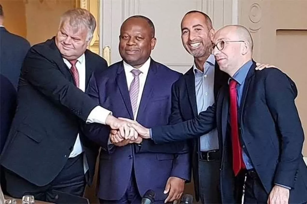 Quatre hommes en costume qui se serrent la main