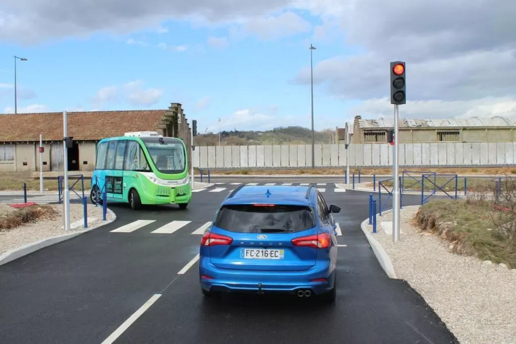 Voiture bleu à un feu rouge avec un minibus