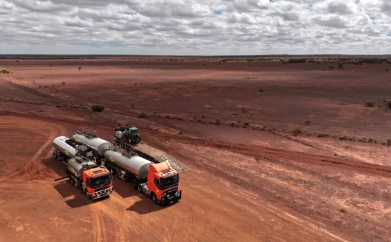 Camions sur chantier routier en environnement désertique