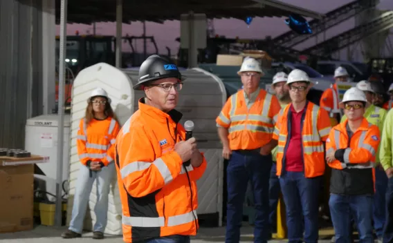 Un manager Colas en gilet haute visibilité s’adresse au personnel casque sur la tête pour renforcer la culture santé-sécurité et l’objectif zéro accident.