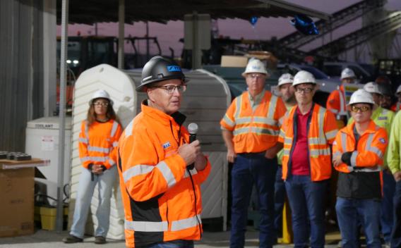 Un manager Colas en gilet haute visibilité s’adresse au personnel casque sur la tête pour renforcer la culture santé-sécurité et l’objectif zéro accident.