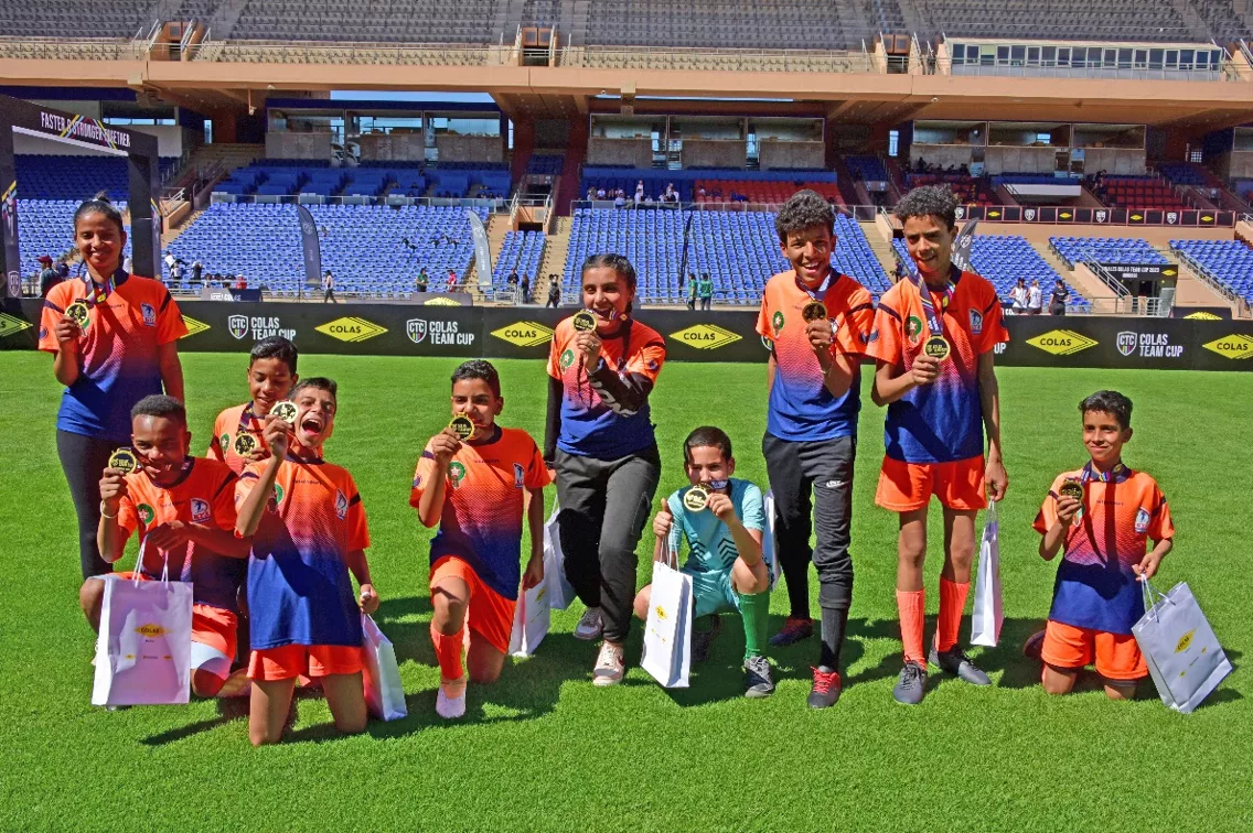 child’s soccer team in a stadium, with medals
