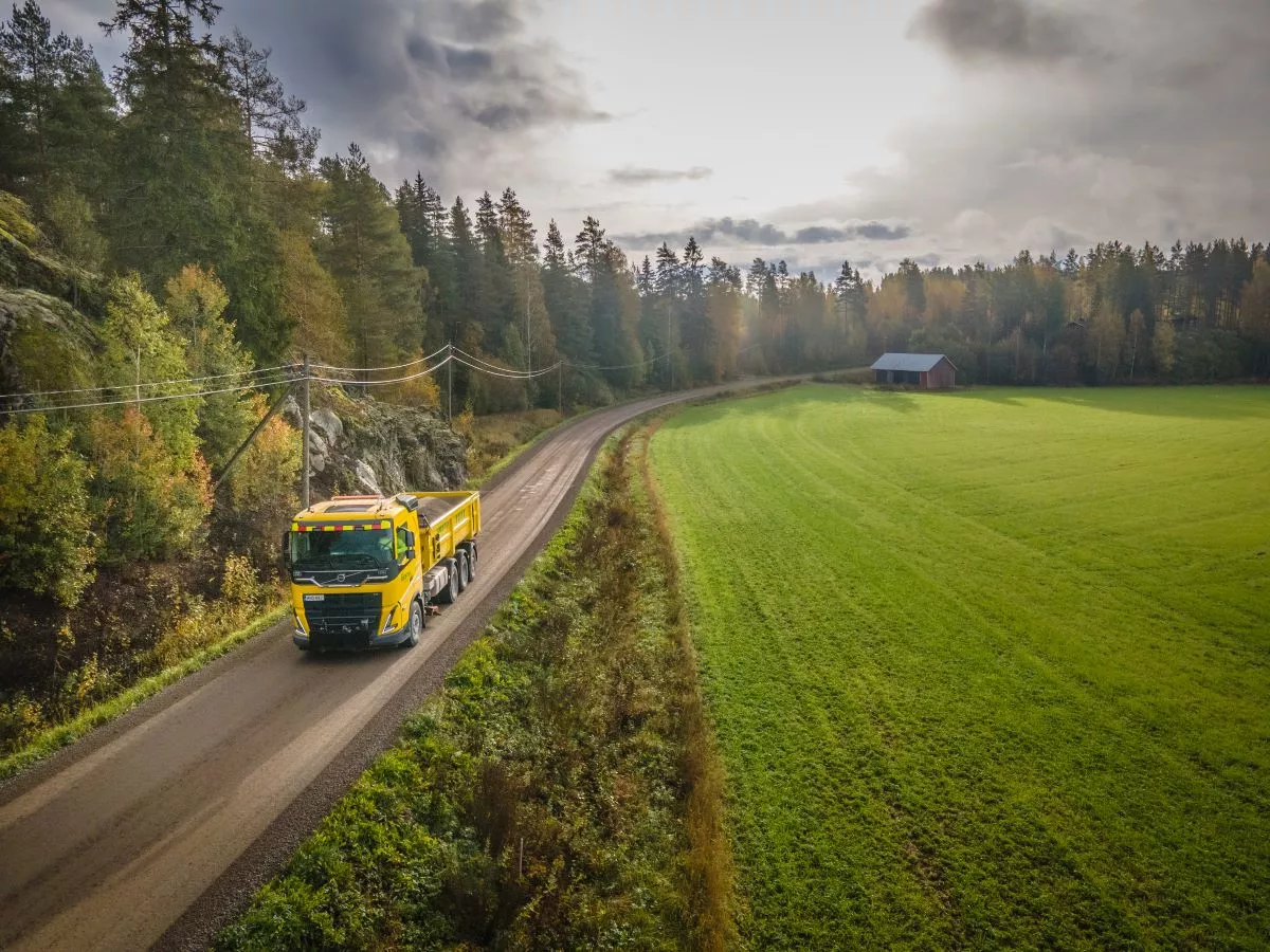 Camion sur une route de campagne entourée de forêts et de champs