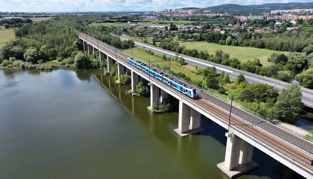 Railway bridge crossing a river, modern train, green landscape