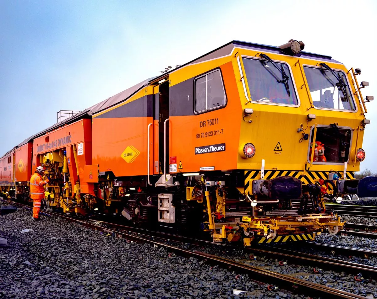 Engin ferroviaire en opération sur voie, collaborateurs en intervention.