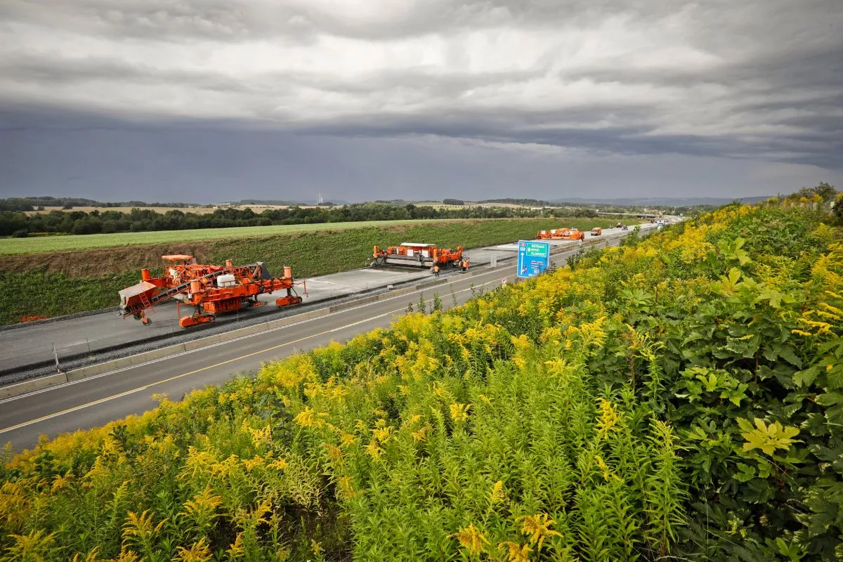 Work on a country road under cloudy skies.