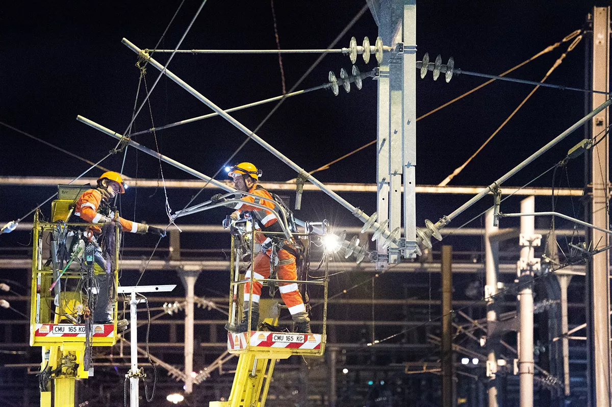 Employees at heights equipped with protection, perform work on an electrical infrastructure during the night
