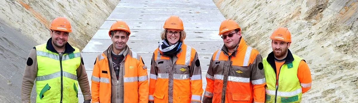 Cinq collaborateurs posant pour une photo