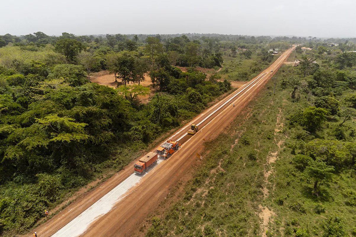 Road construction in forest areas, trucks at work.