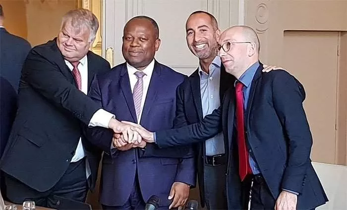 Quatre hommes en costume qui se serrent la main